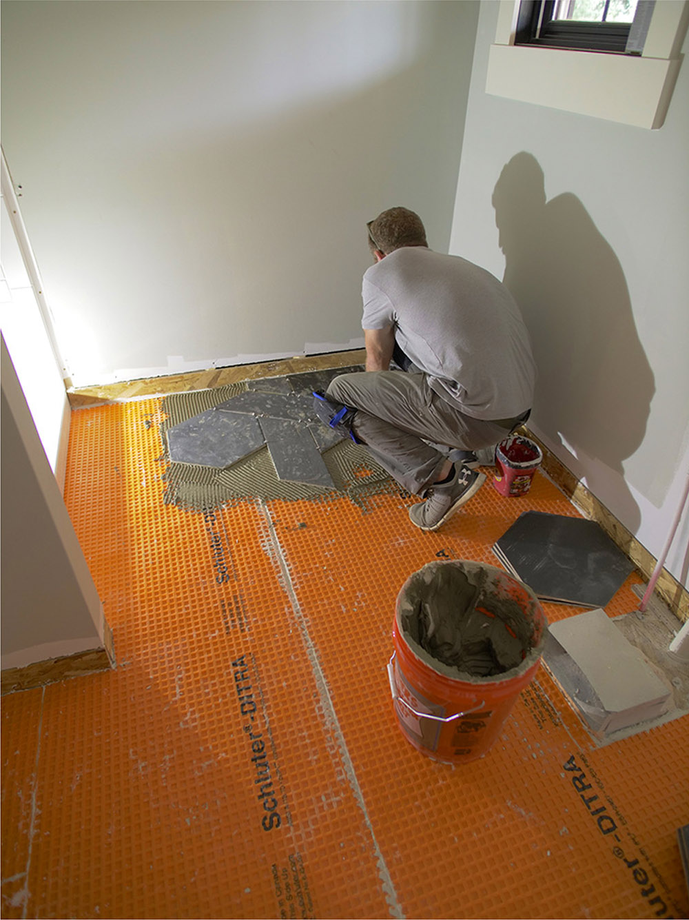 Man installing naveta and hex tiles on the floor.