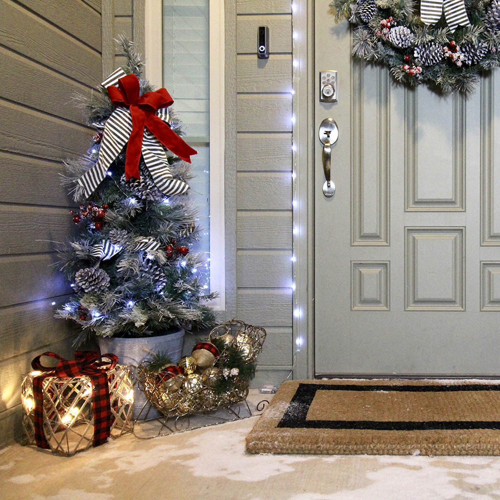 A front entryway with an artificial Christmas tree and Christmas decorations.