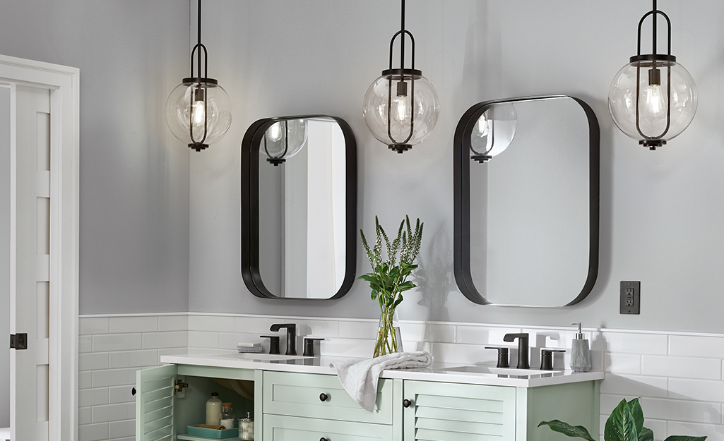 A bathroom vanity with hanging pendant lights.