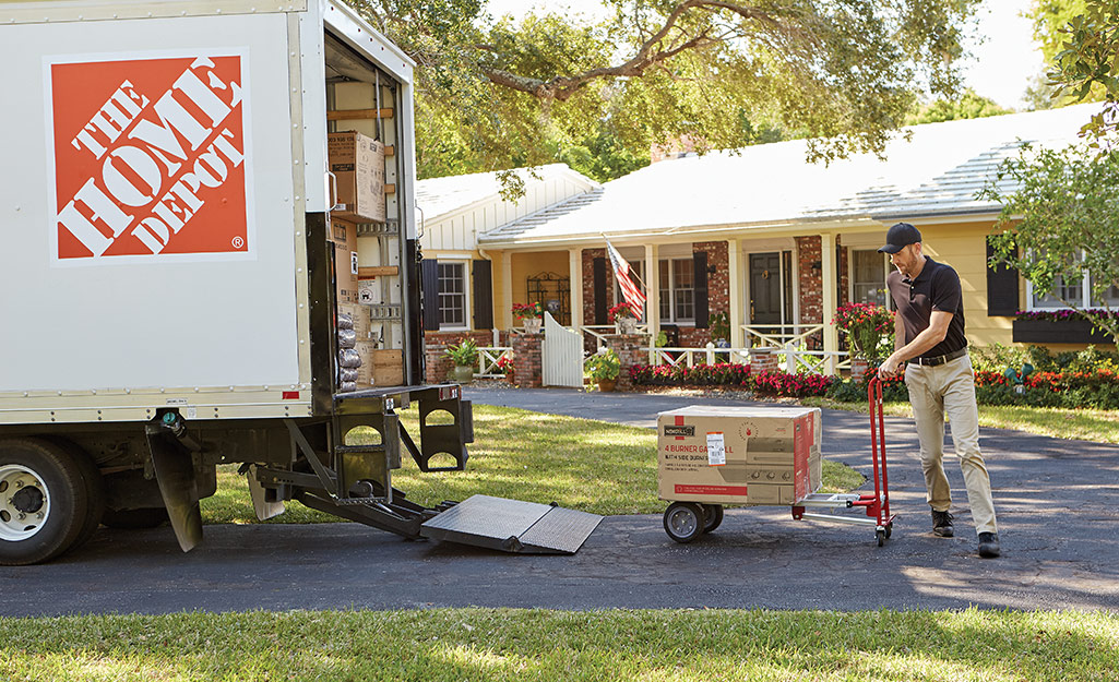 A delivery man drops off items from The Home Depot.