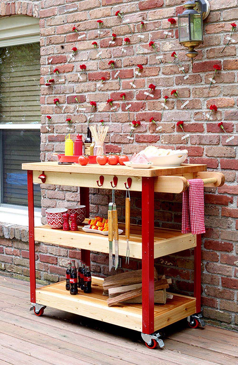 A DIY grill cart with red accents made from metal, cedar, and butcher block.