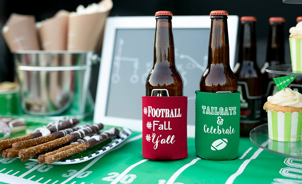 A table decorated in football decor features snacks and beverages.