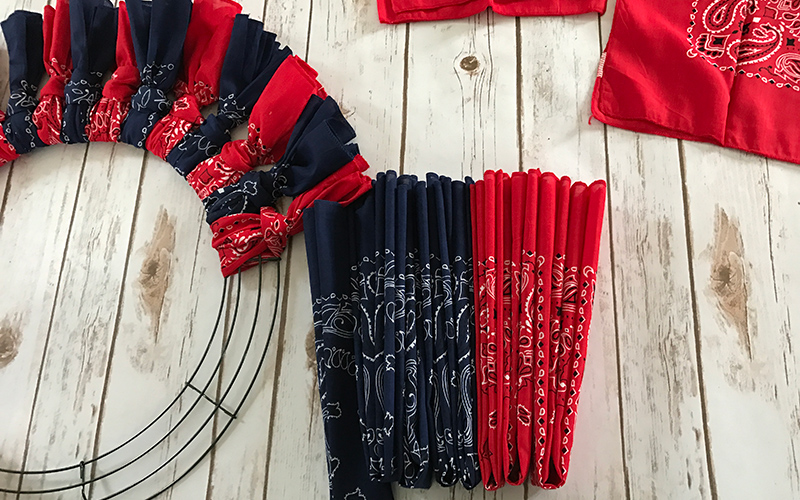 Folded bandanas sit next to a wire form being used to create a bandana wreath.