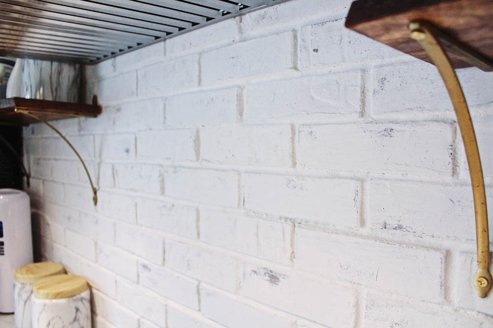 The completed limewashed brick backsplash wall.