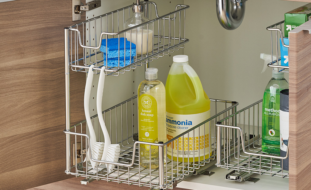 A metal under cabinet organizer with laundry supplies.