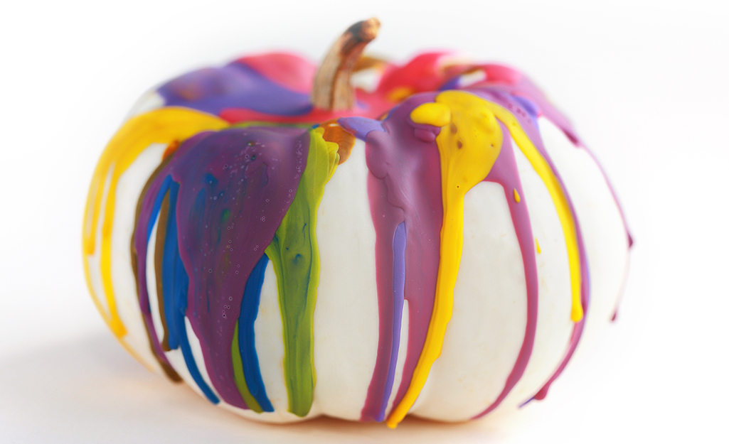 A white pumpkin covered with colorful crayon drips. A white pumpkin covered with colorful crayon drips.
