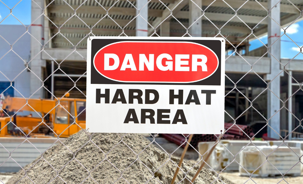 A warning sign hangs outside a construction site.