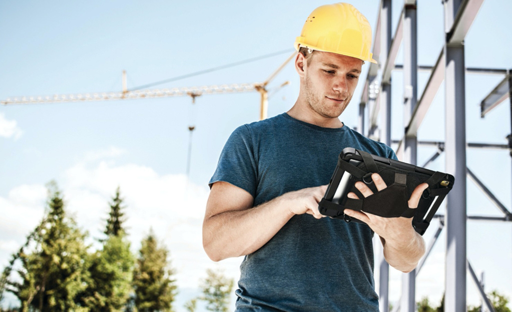 A worker records information on a pad in a carrying case.