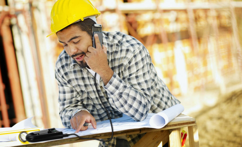 A worker makes a call from a job site.
