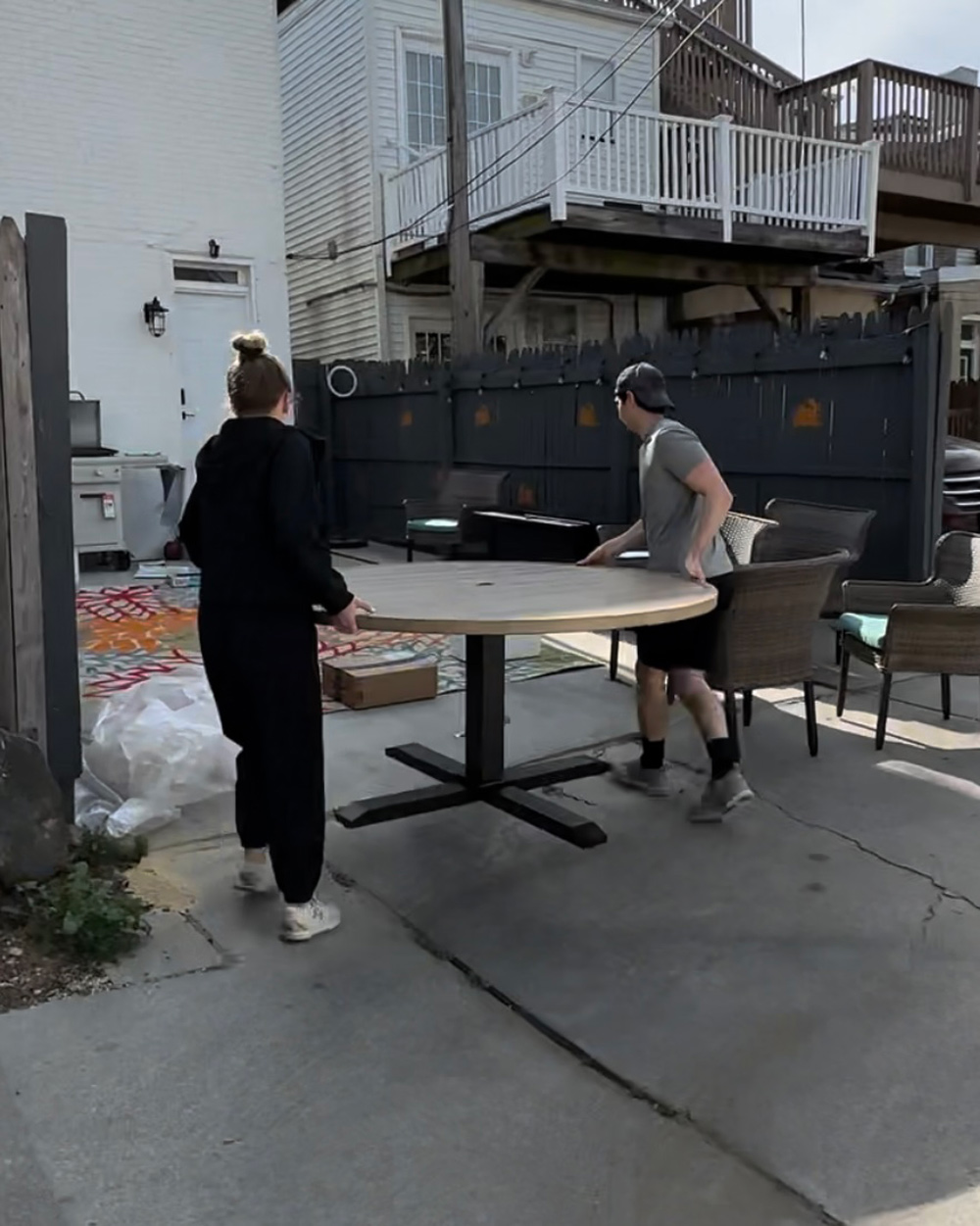 Two people moving a round dining table set. Two people moving a round dining table set.