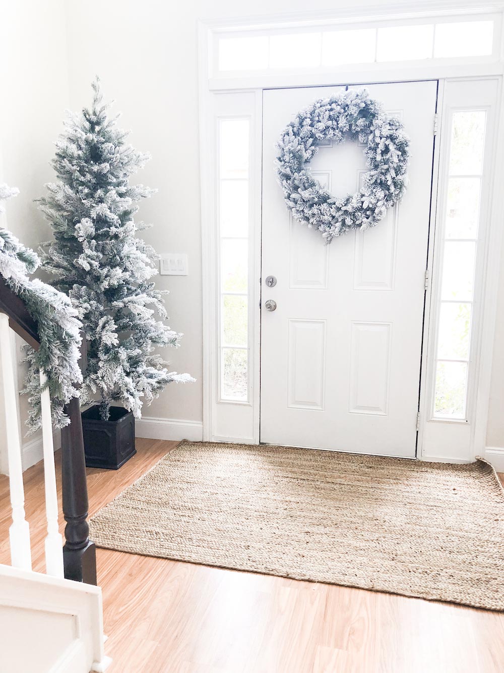 Natural area rug on floor with decorated holiday wreath on back door.