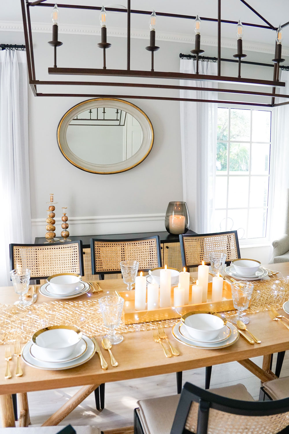 Wooden table decorated with chandelier overhead.