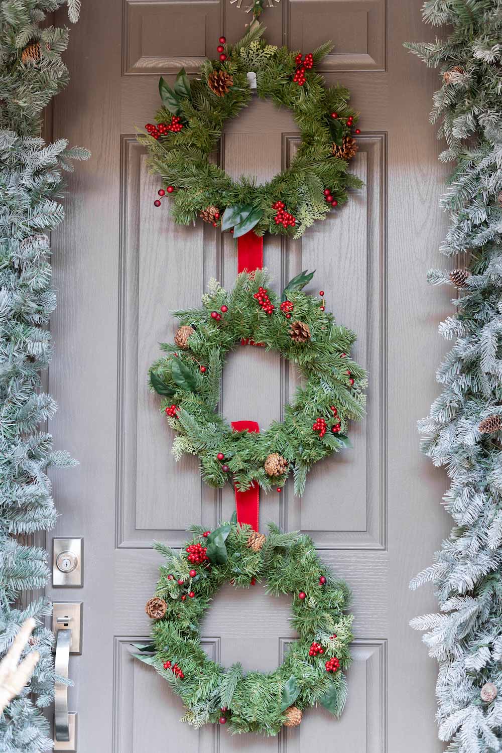 A front door is styled with garland, and wreaths shot head on