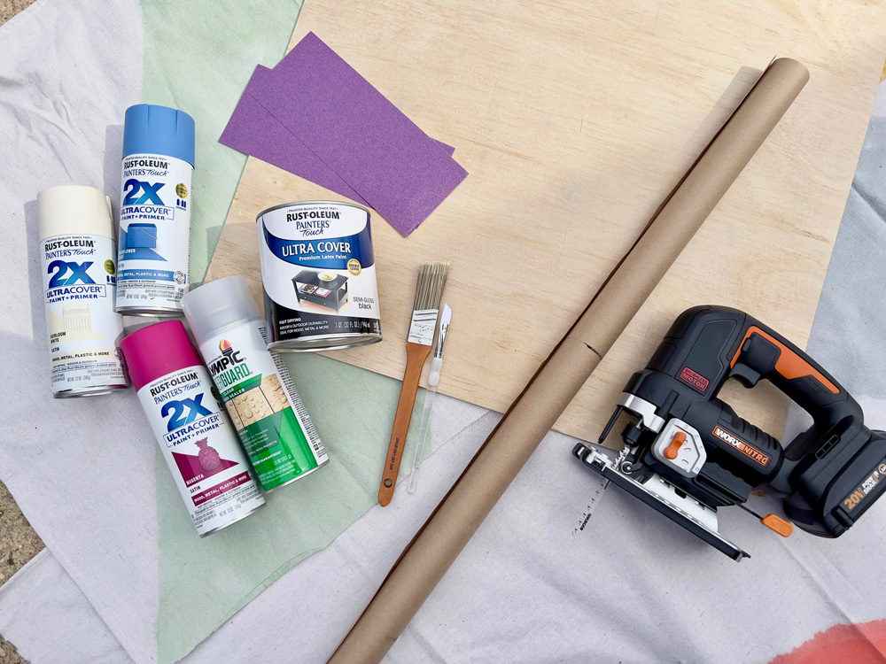Photo of laid-out project materials including spray paint, jigsaw, and paintbrush.