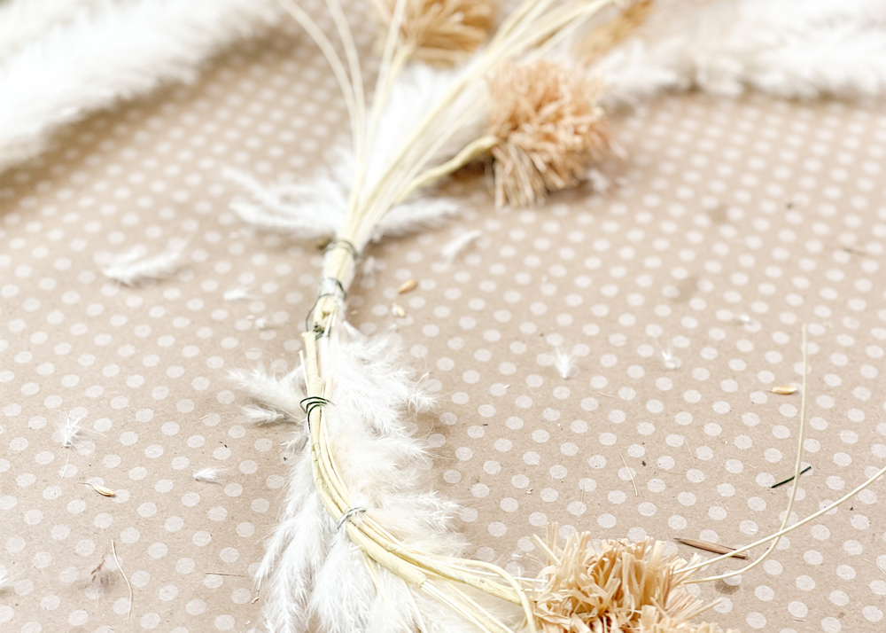 Pampas grass attached to metal hoop with floral wire.