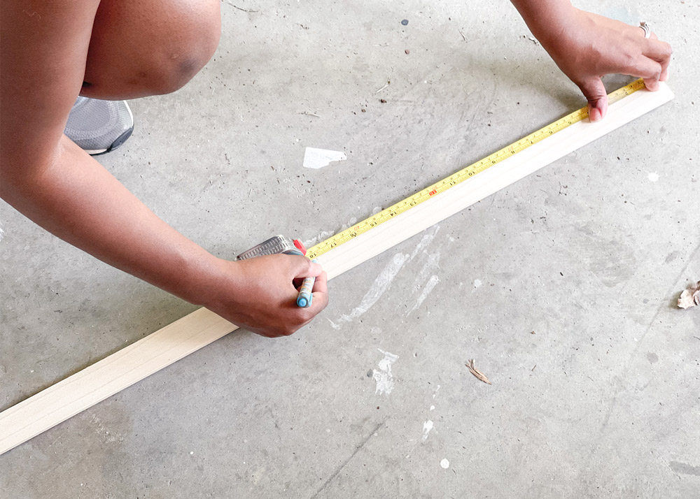 Person measuring and marking poplar boards.