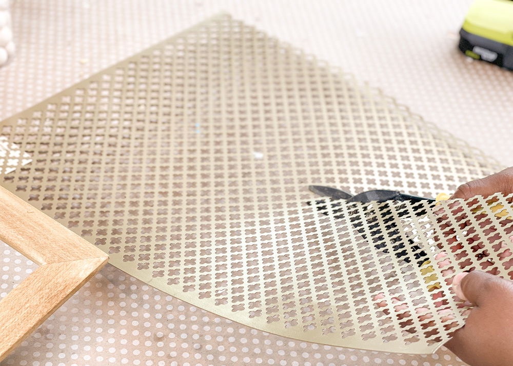 Person cutting gold aluminum sheet with tin snips.