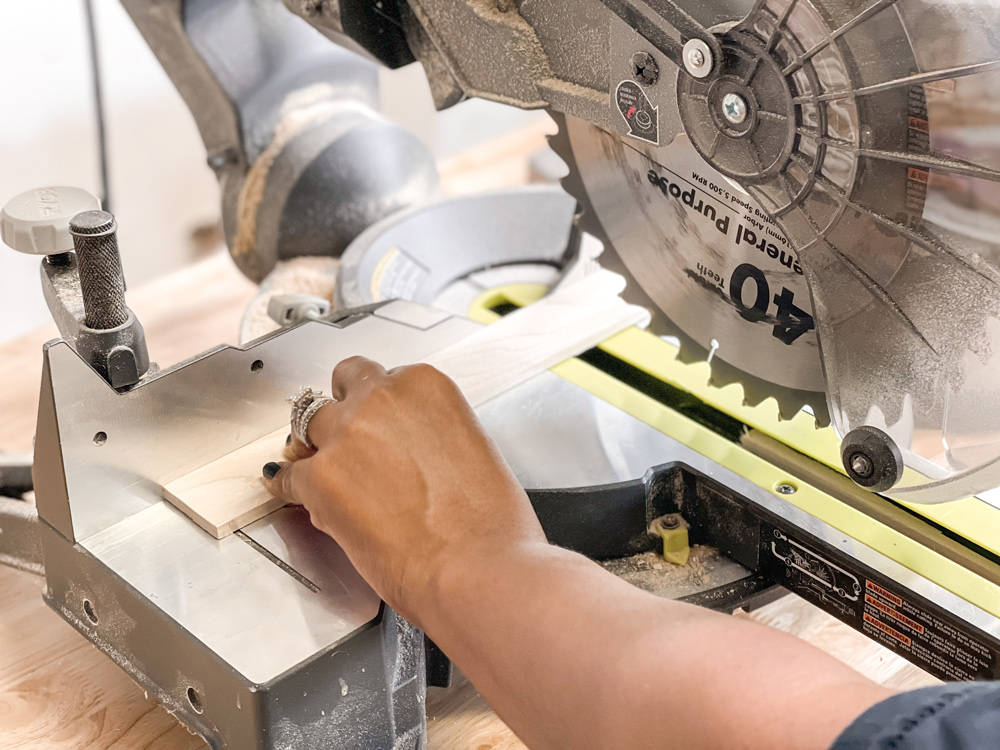 Hands using a circular table saw to cut a wooden board Hands using a circular table saw to cut a wooden board