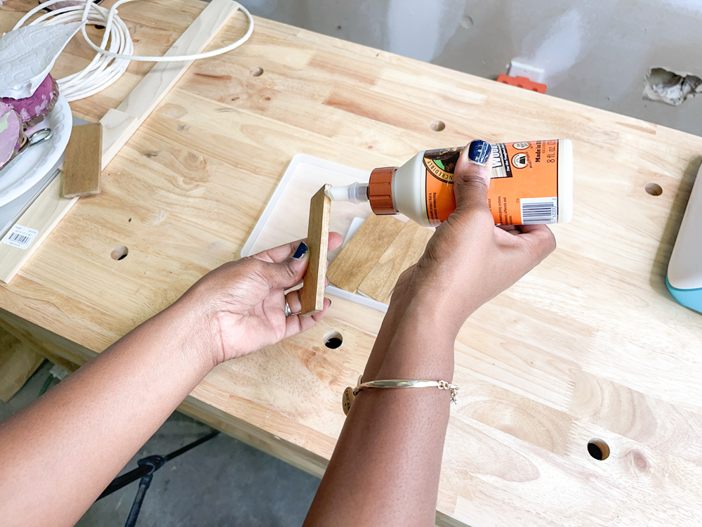 Hands applying wood glue to the edge of a piece of wood Hands applying wood glue to the edge of a piece of wood
