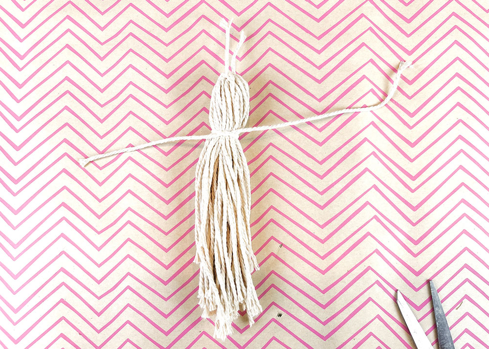 Piece of macrame tied around base of macrame ghost.