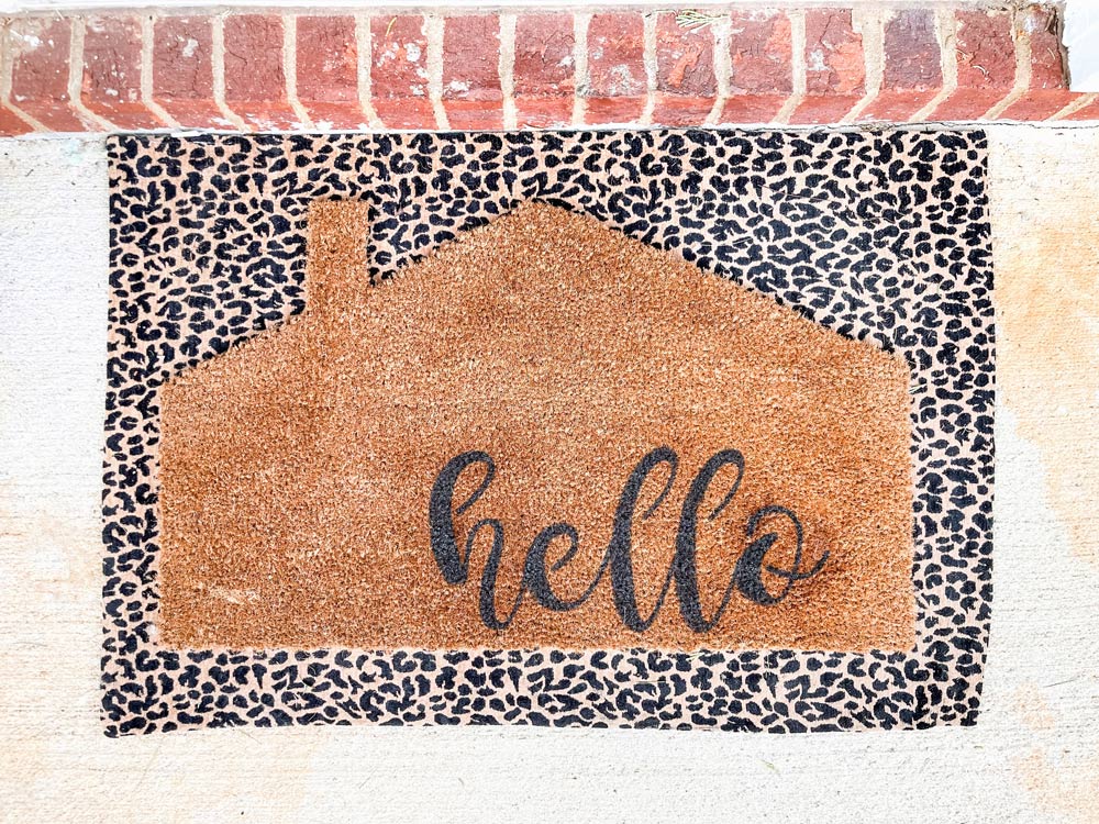 A completed DIY Welcome Mat layered on a cheetah print doormat.