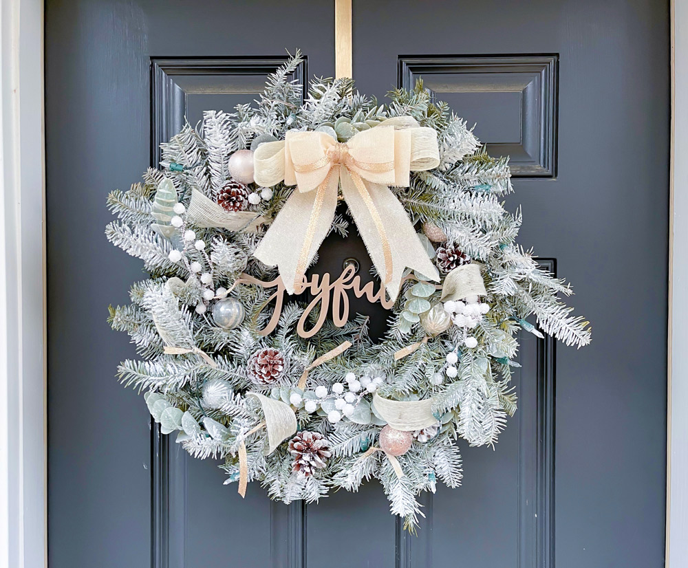 A finished DIY Flocked Wreath hanging over a door.