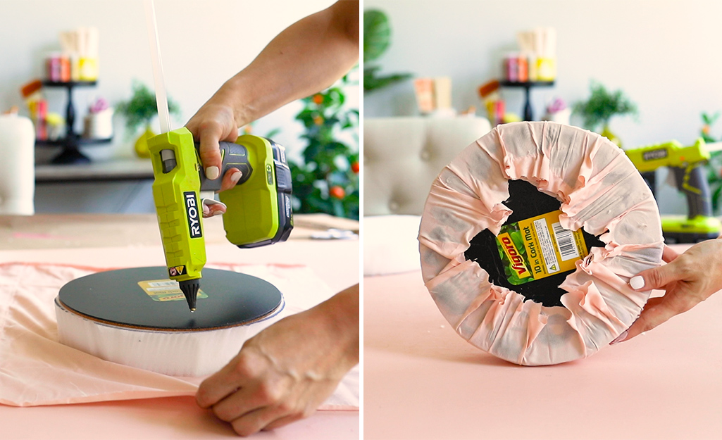 A woman using hot glue to secure fabric to a 10-inch round cushion.