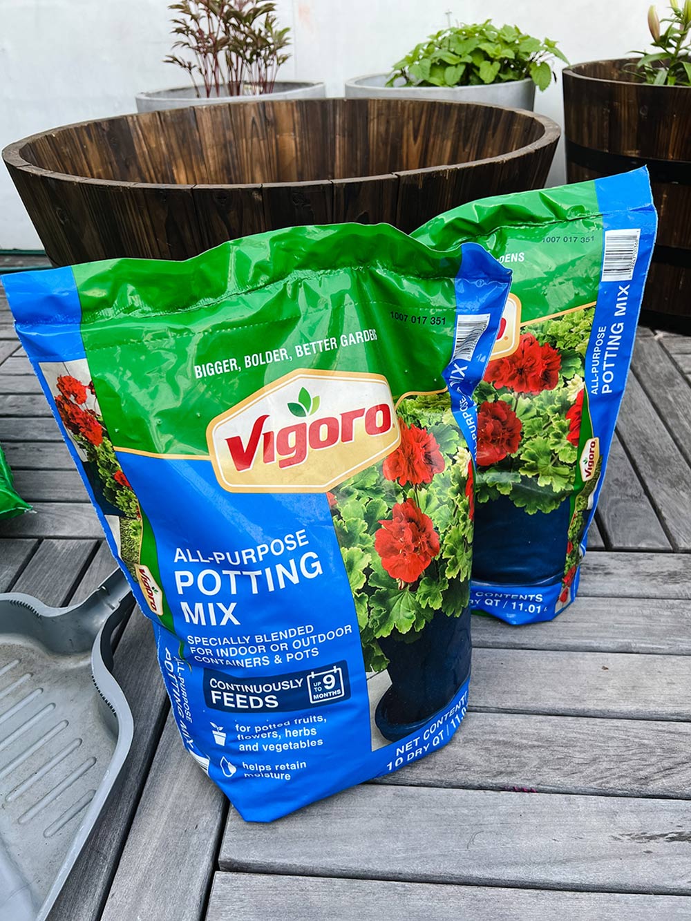2 bags of Vigoro potting mix in front of an empty planter.
