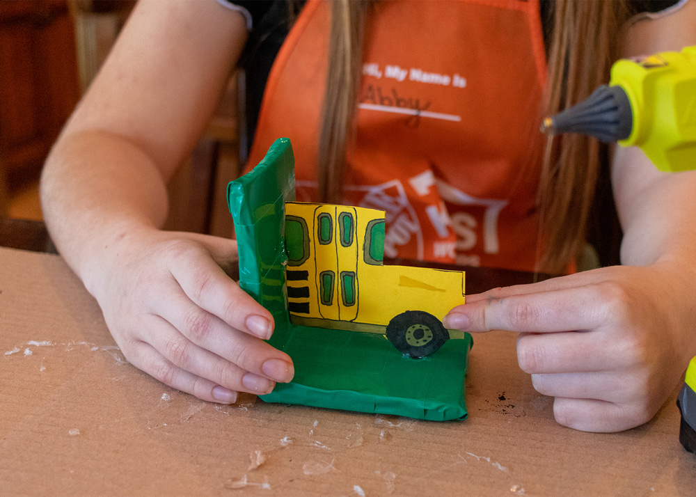 Child holding bookend and cut-out school bus.