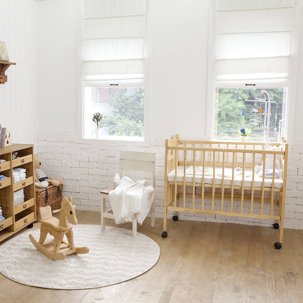 A baby's nursery with blinds on the windows.