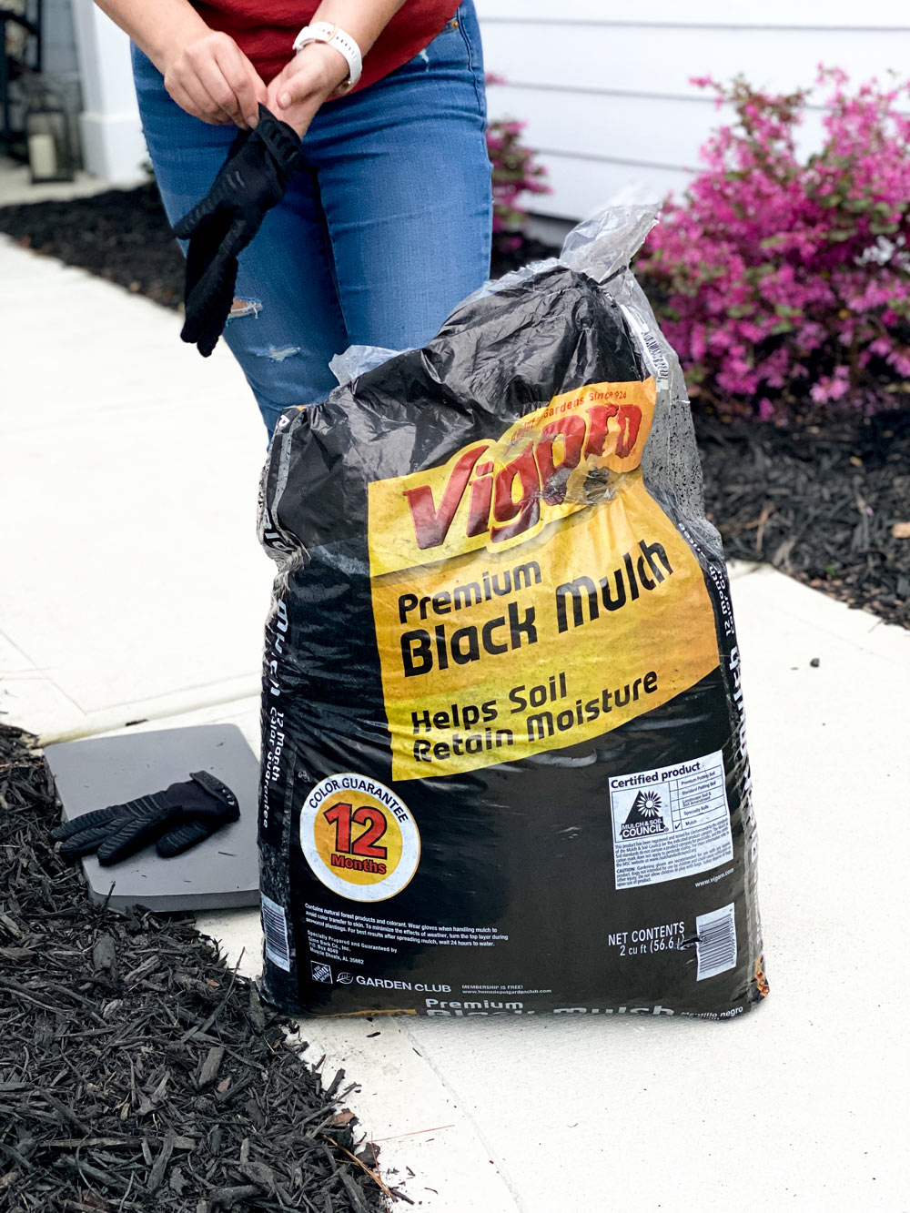 Person putting on gloves for Vigoro Black Mulch.