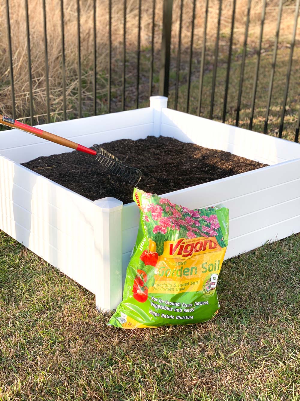 Raised garden bed with a bag of Vigoro garden soil.