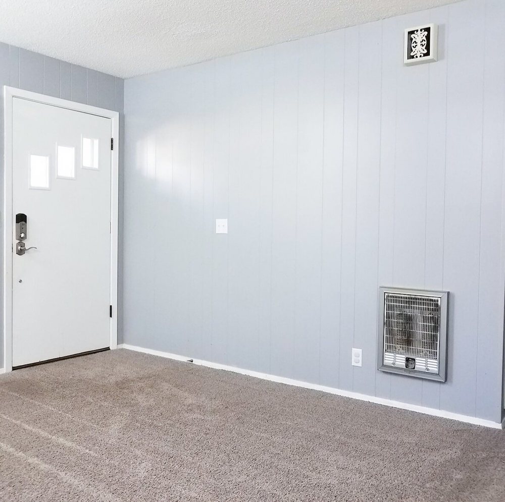 Pastel blue wall with a white door on the right hand side