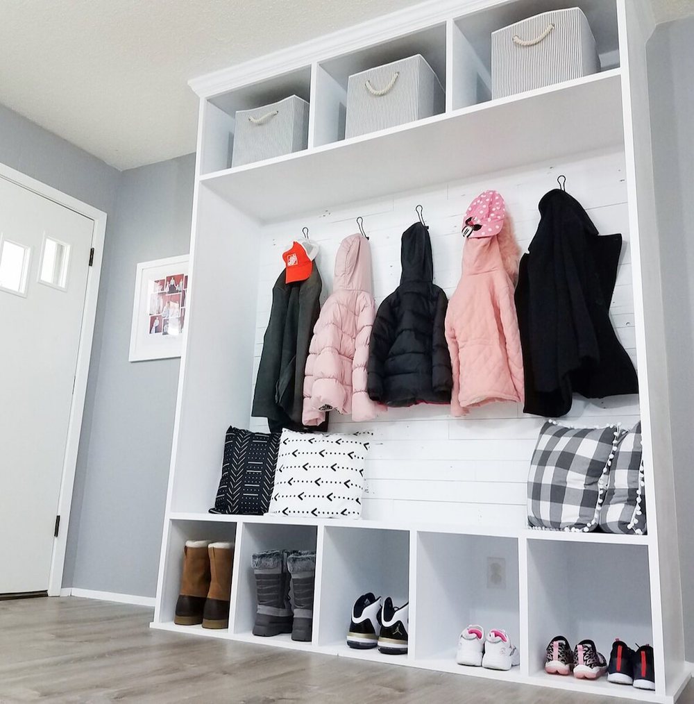 DIY coat closet filled with coats, shoes, pillows and organizers