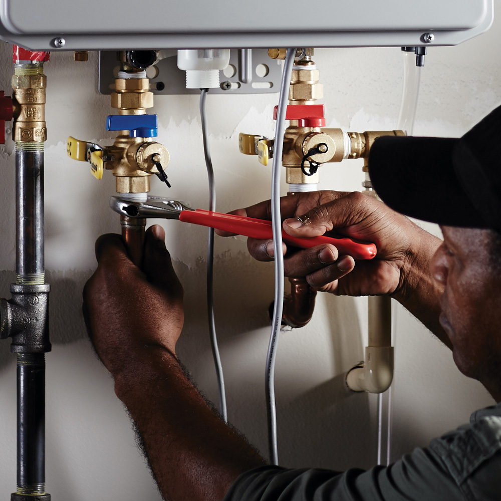 A person installs a commercial water heater.