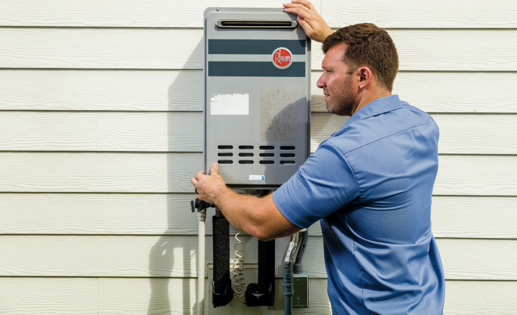A person installs a tankless water heater.