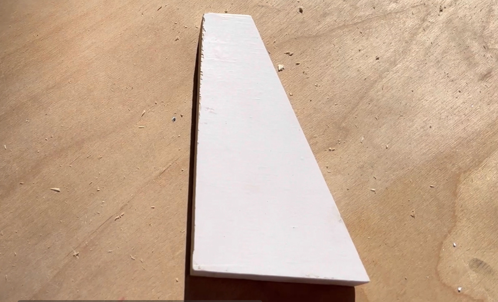 A wooden board with an angled wedge end.
