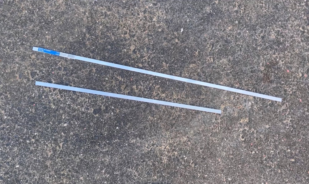 Two aluminum bars on the ground.