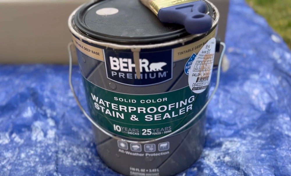 A Behr paint can with a paintbrush resting on the lid.