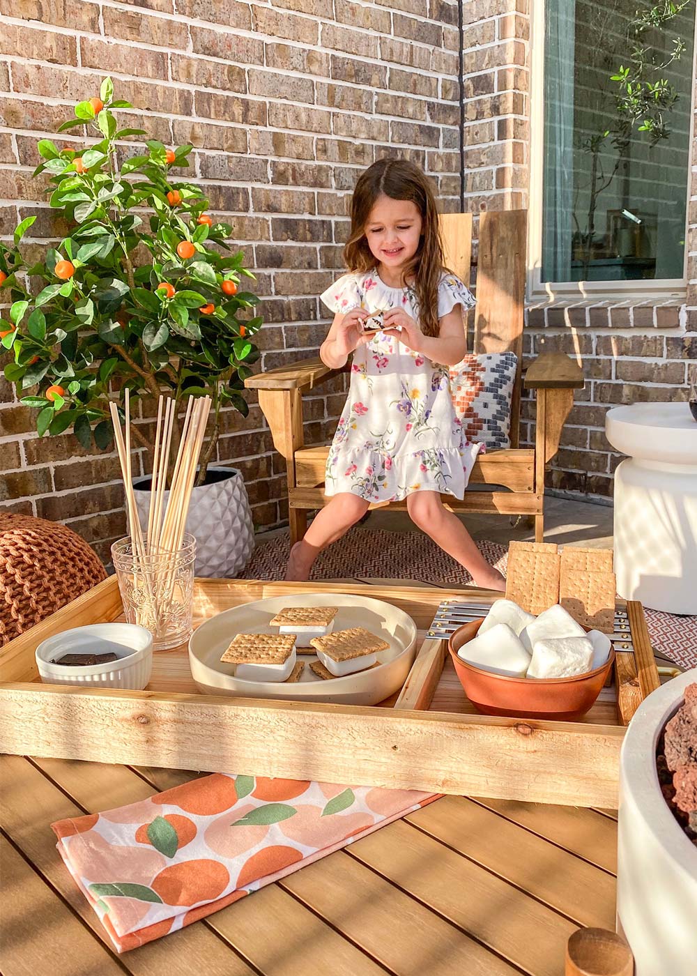 Shot of Cara’s daughter enjoying s’mores from the tray in backyard. Shot of Cara’s daughter enjoying s’mores from the tray in backyard.