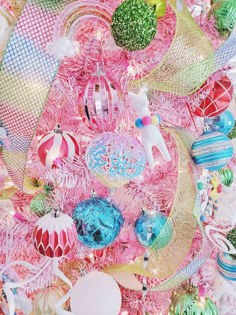 Close up shot of colorful ornaments on a pink tree