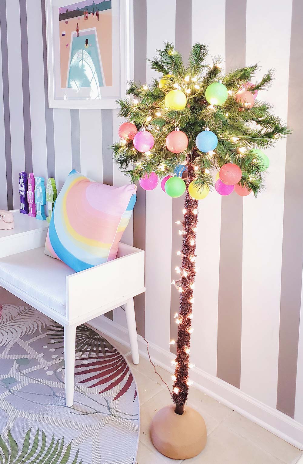 Small indoor palm tree with lights, ornaments and a stripe wall background