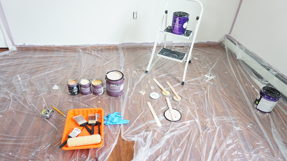 Paint cans and paint materials laying on clear plastic