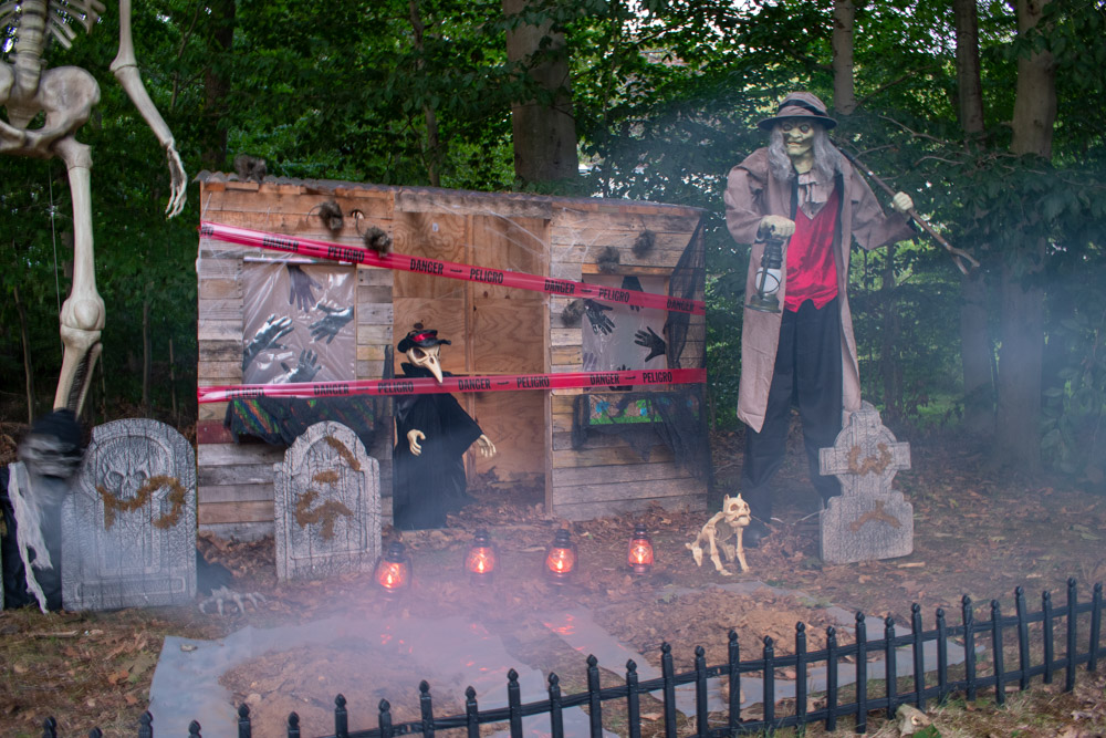 A foggy Halloween graveyard with lanterns and a gravedigger.