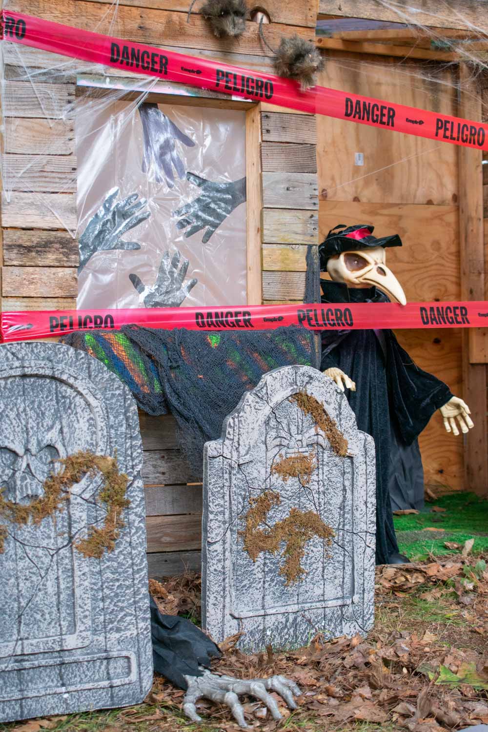 A Victorian reaper standing inside a mausoleum covered in red danger tape.