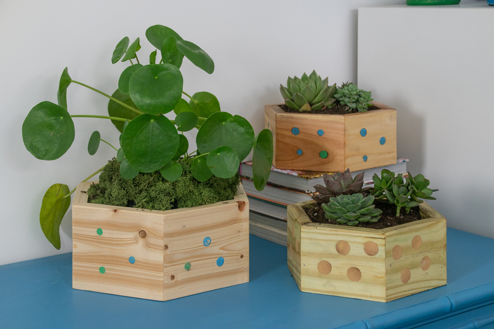 Three finished hexagonal wooden planters.