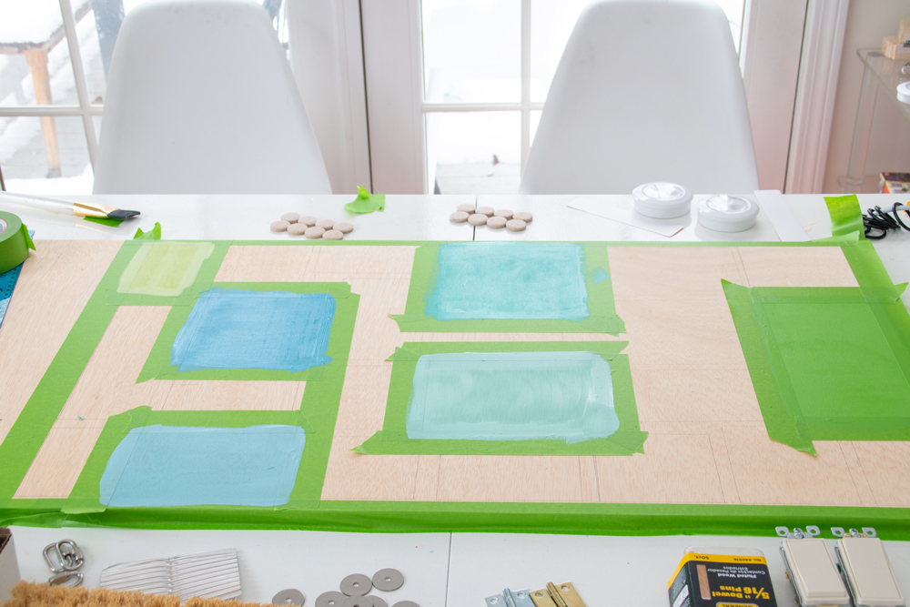 Green painter’s tape on a wooden board with painted centers.