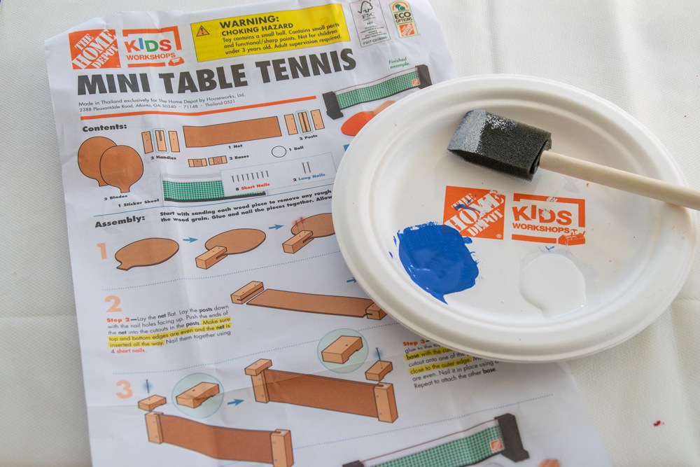 Table tennis mallet kit assembly instructions next to a plate with paint and a foam brush.