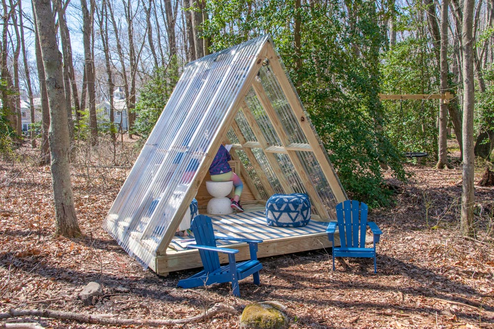A finished A-Frame Luxury Playhouse outdoors.