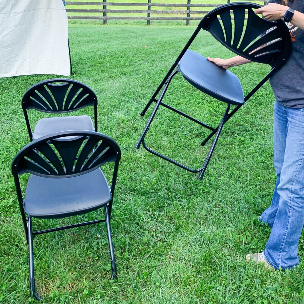 Person unfolding chairs.